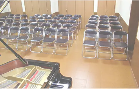 ドルチェ音楽学園 貸しスタジオ:椅子が並ぶ部屋とグランドピアノ