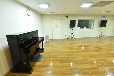 岩槻駅東口コミュニティセンター 音楽スタジオ：音楽スタジオのアップライトピアノとスピーカー