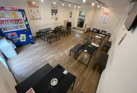 リフレクトスタジオ新栄店：テーブルと自販機のある待合スペース