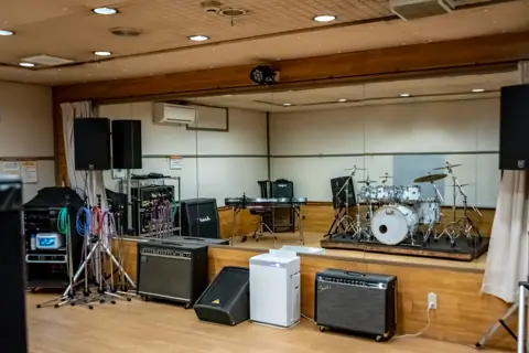 神戸ロッククラブ スタジオ練習：ステージ上にドラムセットとアンプのある室内